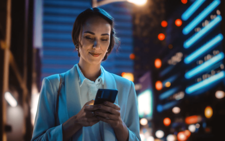 woman looking at phone with cityscape in the background