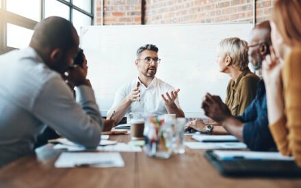 Higher ed executives in a meeting room discussing a marketing strategy in this new AI era
